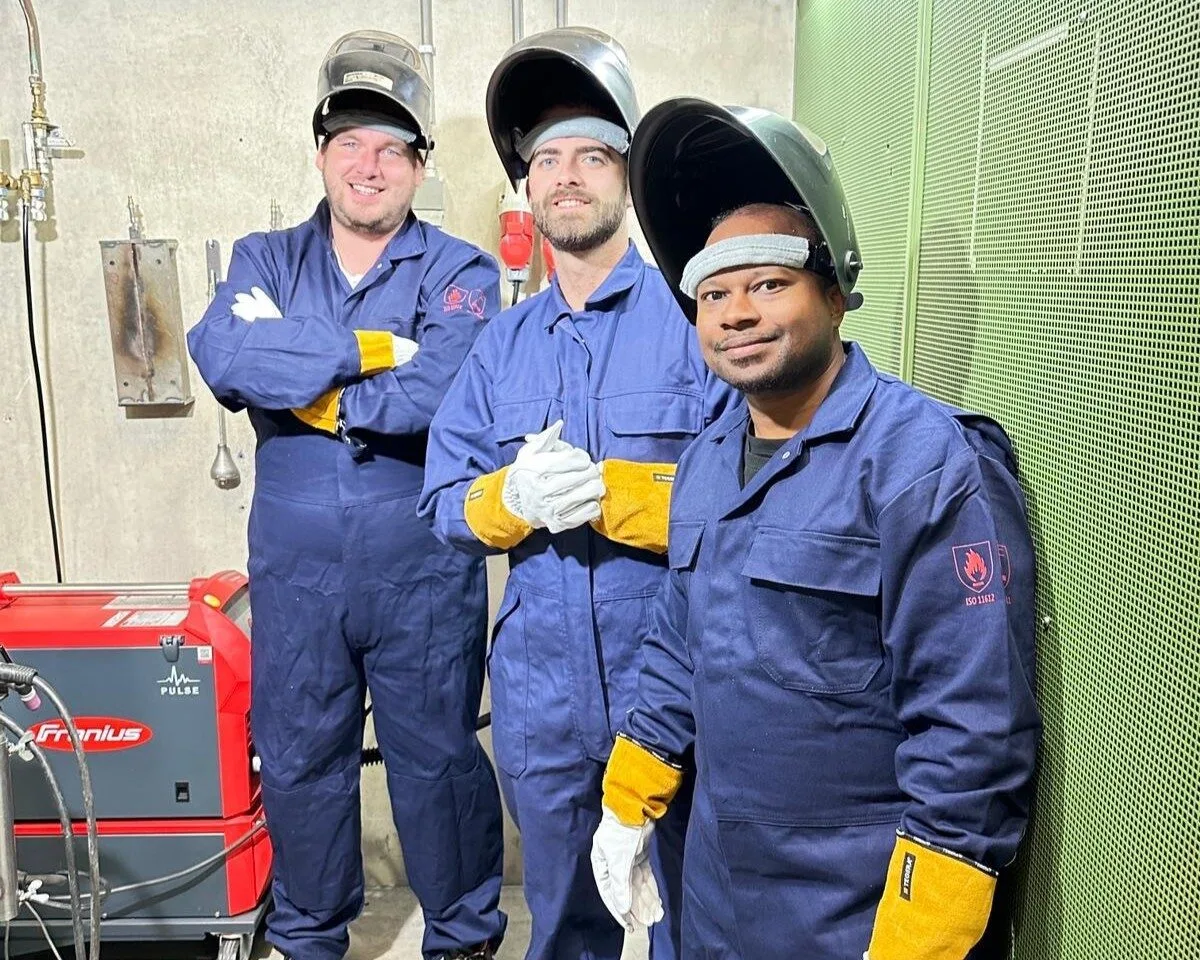 Lassers van IP Techniek in werkkleding en met laskap bij een lasapparaat